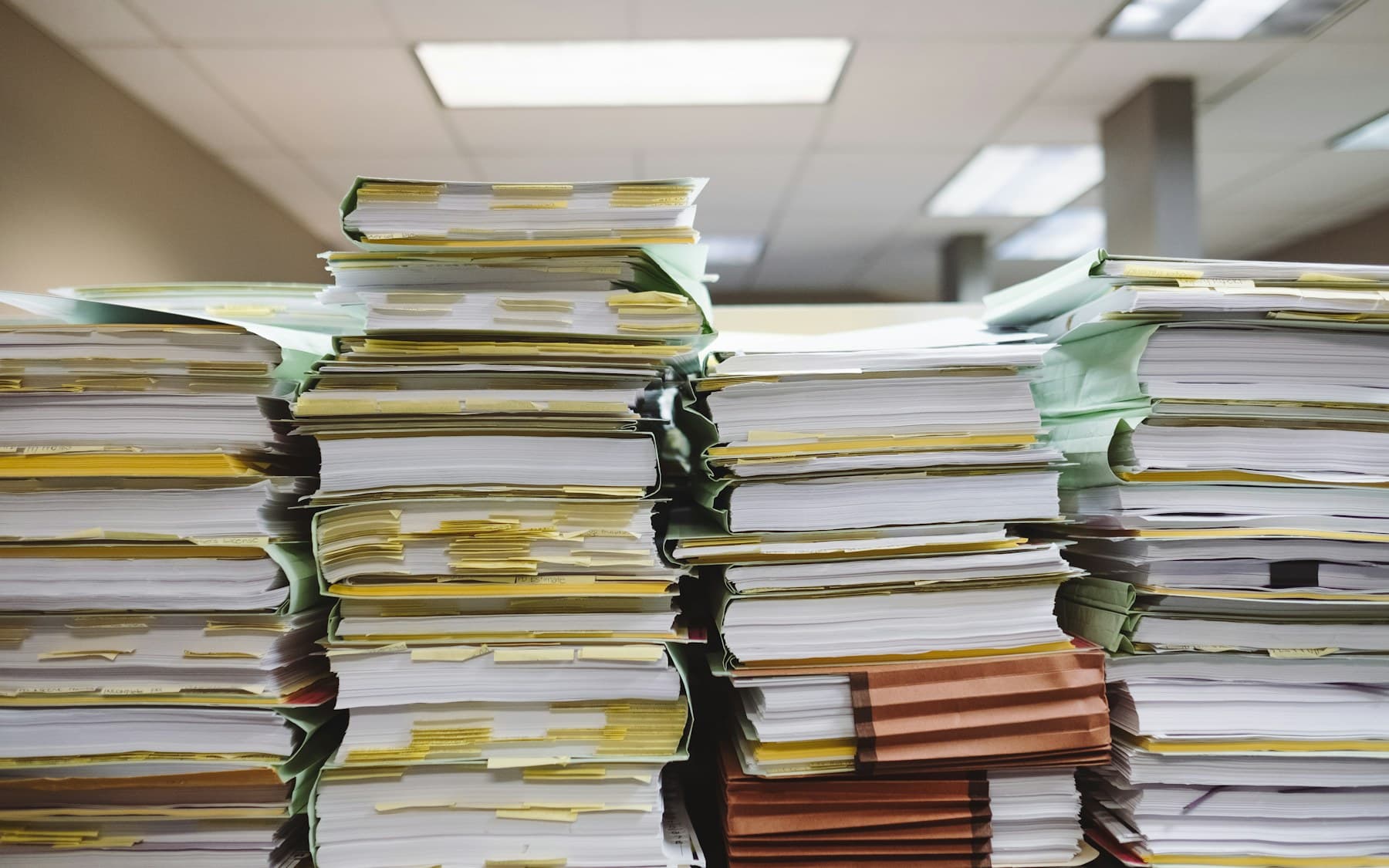 Stacks of indexed paper files representing regulatory document retrieval